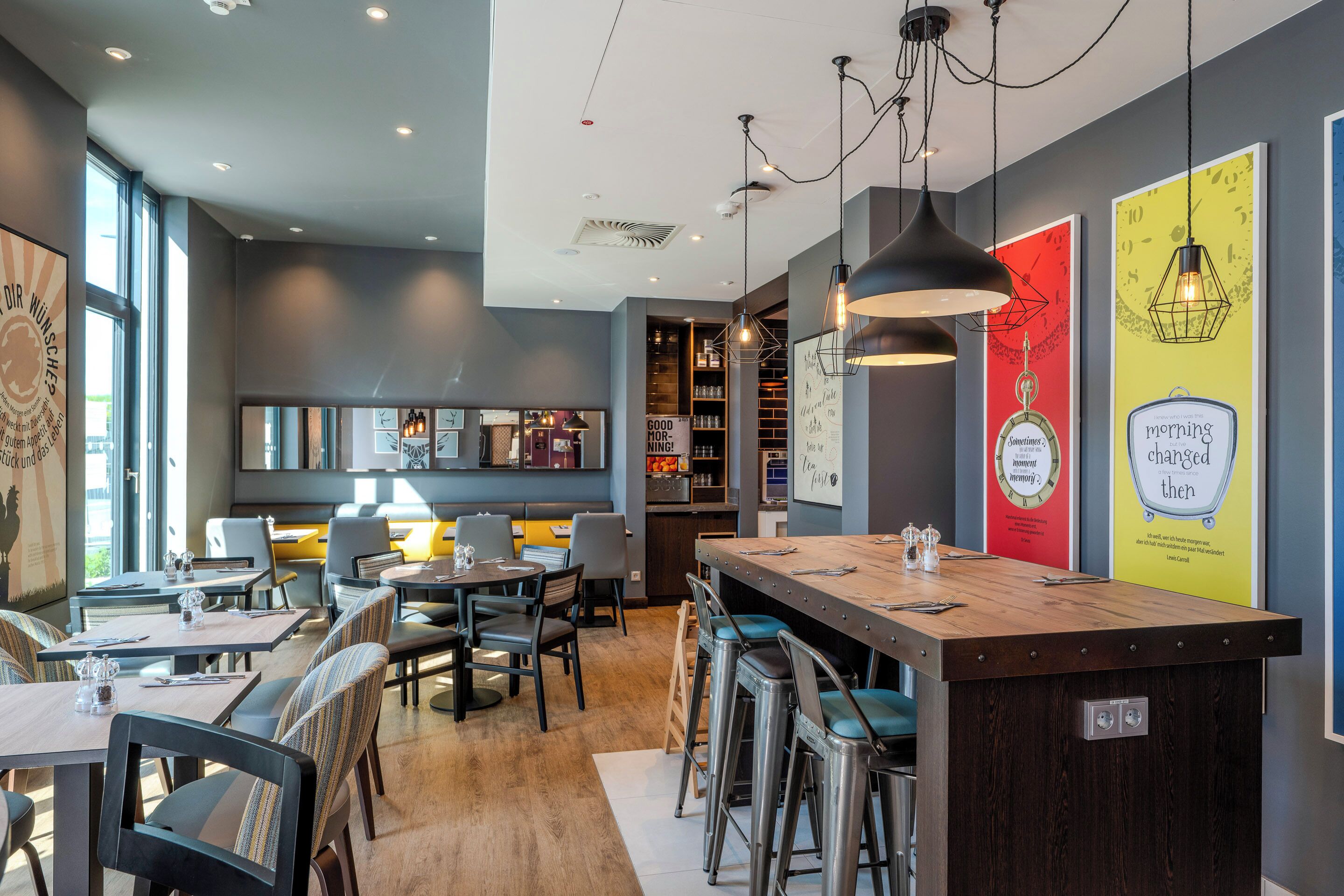 A modern restaurant with a bar area, dining tables, and chairs.
