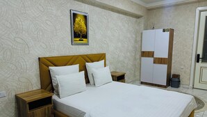 A neatly arranged bedroom with a bed, wooden nightstands, a wardrobe, and a wall-mounted picture. - ALI HOTEL (Namangan)