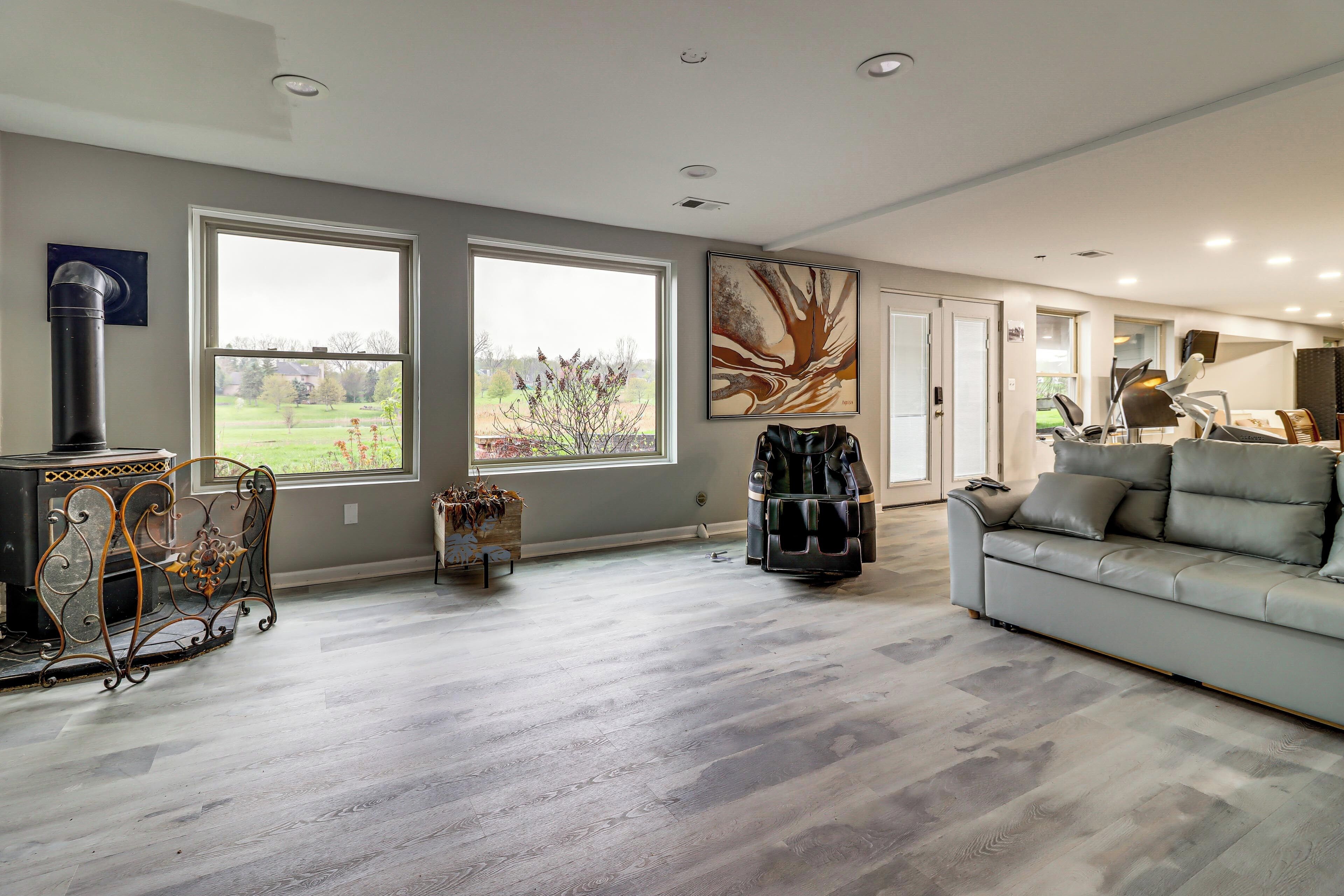 A spacious living room with large windows, a fireplace, and a modern sofa.