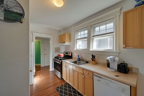 A kitchen with wooden cabinets, a dishwasher, a stove, and a coffee maker. - Ventnor City Getaway w/ Yard: 2 Blocks to Beach! (Ventnor City)