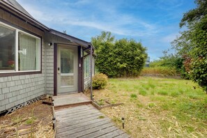 A house with a wooden deck, a door, and a window.