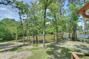 A wooded area with a wooden deck and a view of a lake. - Deck & Dock Access! Sunlit Lake Livingston Escape (Pointblank)