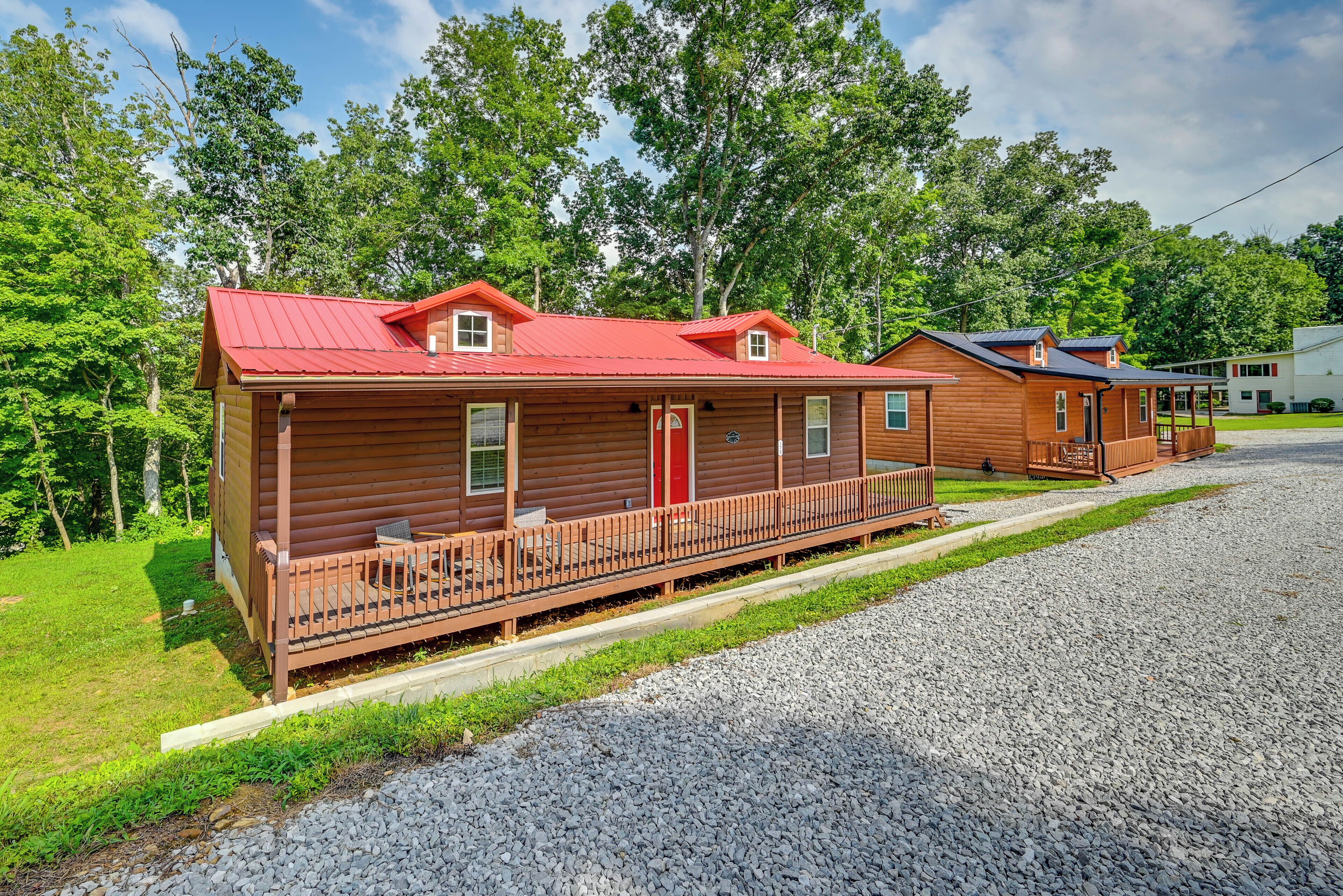 A row of log cabins with a gravel driveway and a wooden deck.