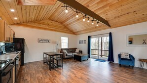 A spacious living area with a kitchen, wooden ceiling, and a view of the outdoors. - 2 Cabins Near Lake Cumberland Boat Ramps! (Somerset)