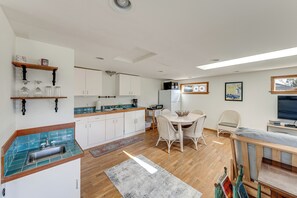 A modern kitchen with white cabinets, a wooden countertop, and a dining area with a table and chairs. - Walkable, Dog Friendly! Friday Harbor Stay w/ Deck (Friday Harbor)