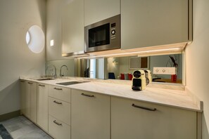 A modern kitchen with a built-in microwave, a sink, and a countertop. - Luis de Vargas 2.2 by Home at Homes (Seville)