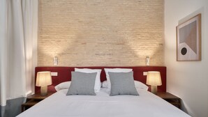 Ein Hotelzimmer mit Bett, zwei Nachttischlampen, einem Kopfteil und einem Wandbild.