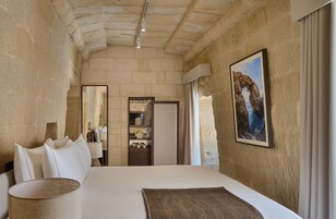 Un dormitorio con una cama grande, un espejo, un armario y un cuadro en la pared.