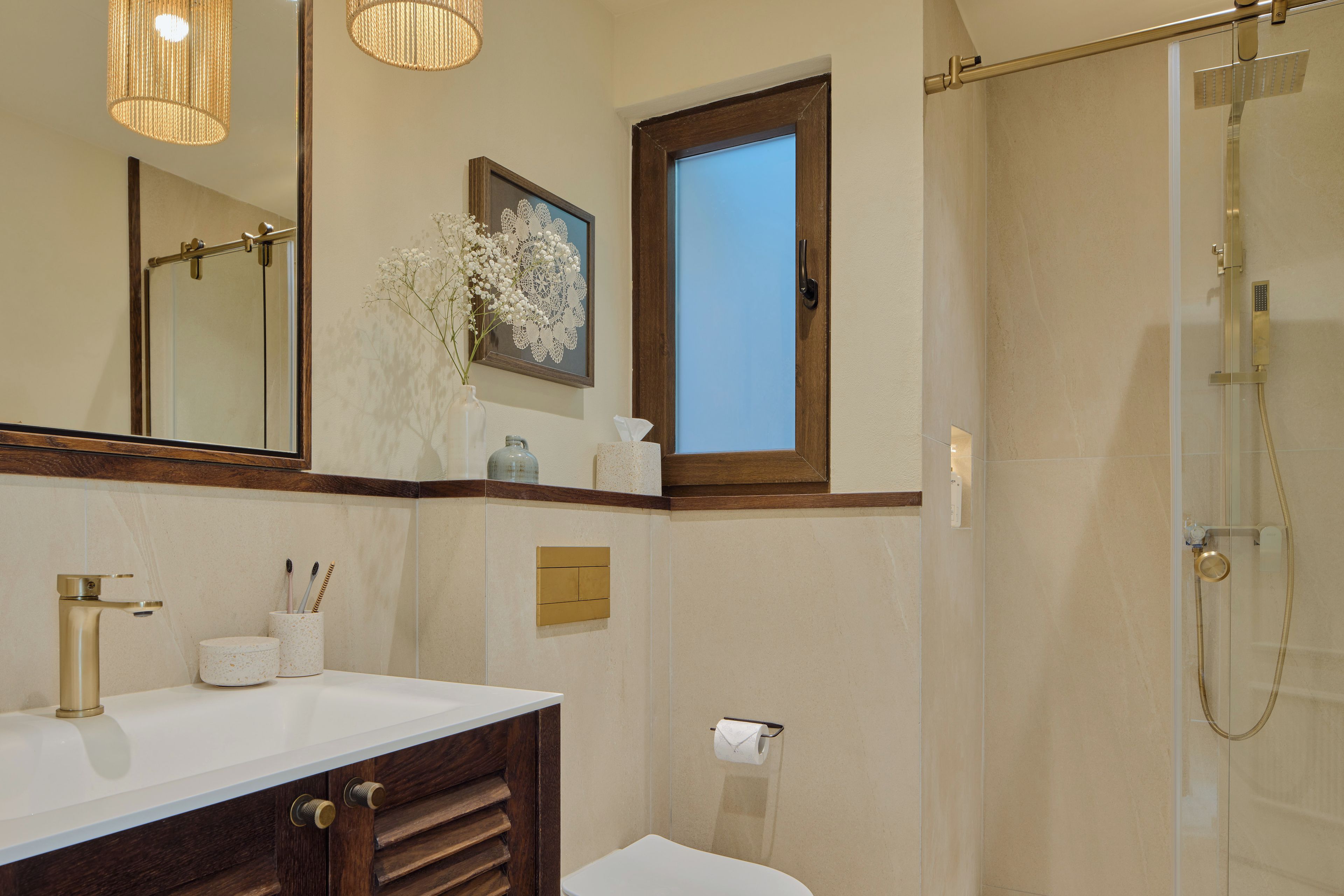 A bathroom with a large mirror, a sink, a toilet, and a shower.