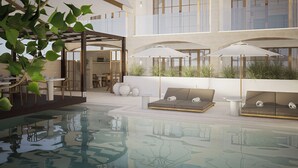 A modern indoor pool area with seating and a glass-enclosed upper level. - Casa Azure Member Of Meliá Collection (San Lawrenz)