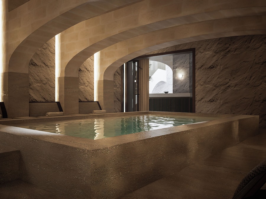 Ein Wellnessbereich mit Pool, Steinwänden und Gewölbedecken.