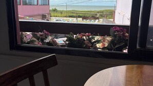 A window view of a building, a chair, and a table.