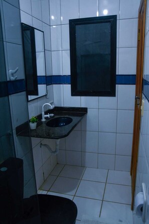 Chuveiro, toalhas de banho, sabonete, papel higiênico