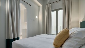 A hotel room with a bed, curtains, a window, and a view of the balcony. - Luis de Vargas 2B by Home at Homes (Seville)