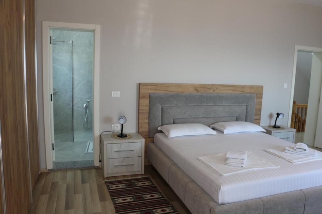 Un dormitorio con cama, mesita de noche y zona de ducha.