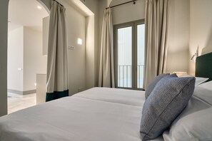 A hotel room with a large bed, a window with curtains, a view of the outside, and a modern design. - Luis de Vargas 1B by Home at Homes (Seville)