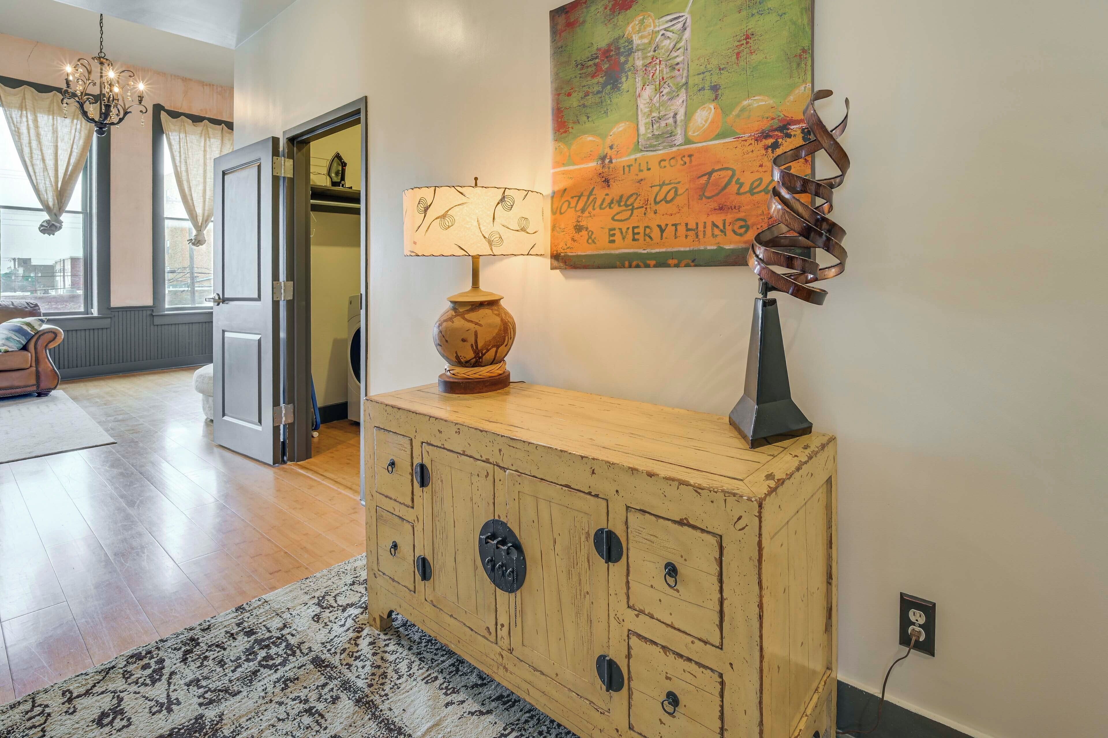 A wooden dresser with multiple drawers, a lamp, and a decorative piece on the wall.