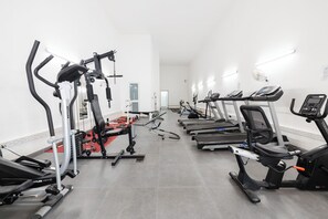 Ett gym med löpband, crosstrainers och utrustning för styrketräning.