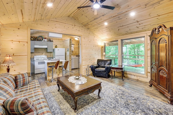 A wooden interior with a sofa, coffee table, and a cabinet.