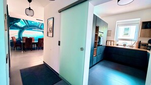 Eine moderne Hotelhalle mit Essbereich, einer Küche und Blick auf ein futuristisches Design.