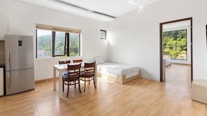 Ett modernt, öppet vardagsrum med kök, matplats och en säng.
