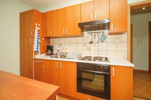 A kitchen with wooden cabinets, a stove, and a sink. - Vacation apartment for 4 people with balcony and private parking space (Crikvenica)