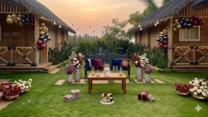 A wooden structure with a thatched roof, a table with a cake, and floral arrangements. - Maharsh Bamboo Stays near Devanahalli (Dyavarahalli)