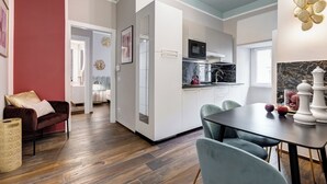 Una cocina moderna con armarios blancos, un microondas negro y un salpicadero de mármol.