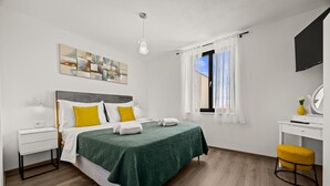 Une chambre à coucher moderne avec un lit, une table de chevet et un bureau avec une chaise.