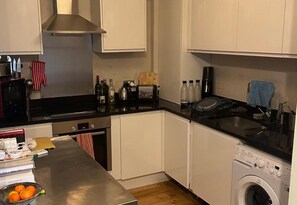 Eine kompakte Küche mit Geschirrspüler, Waschmaschine, Toaster und Kaffeemaschine.