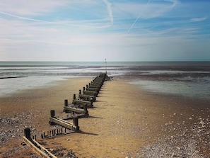 Ein Strand mit einer hölzernen Steg, der ins Meer führt.