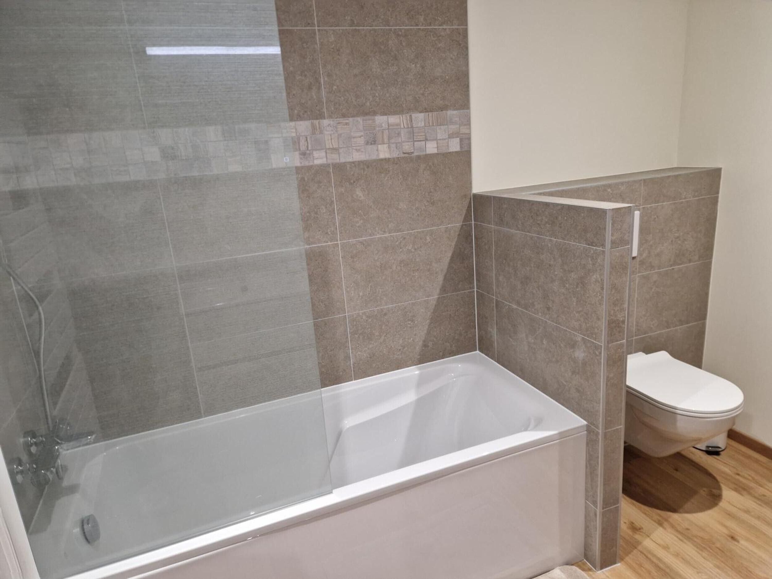Un baño con bañera, inodoro y zona de ducha.