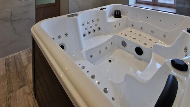 A modern bathroom with a large white bathtub, a glass shower enclosure, and a window providing natural light. - The Forests Cottage for 10 Guests, Near Center Parcs Trois Forêts (Cirey-sur-Vezouze)