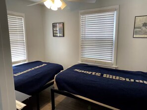 A bedroom with two beds, white walls, a ceiling fan, and a framed inspirational quote. - Less than 2 blocks from Beach w/ 4 beach tags (Seaside Heights)