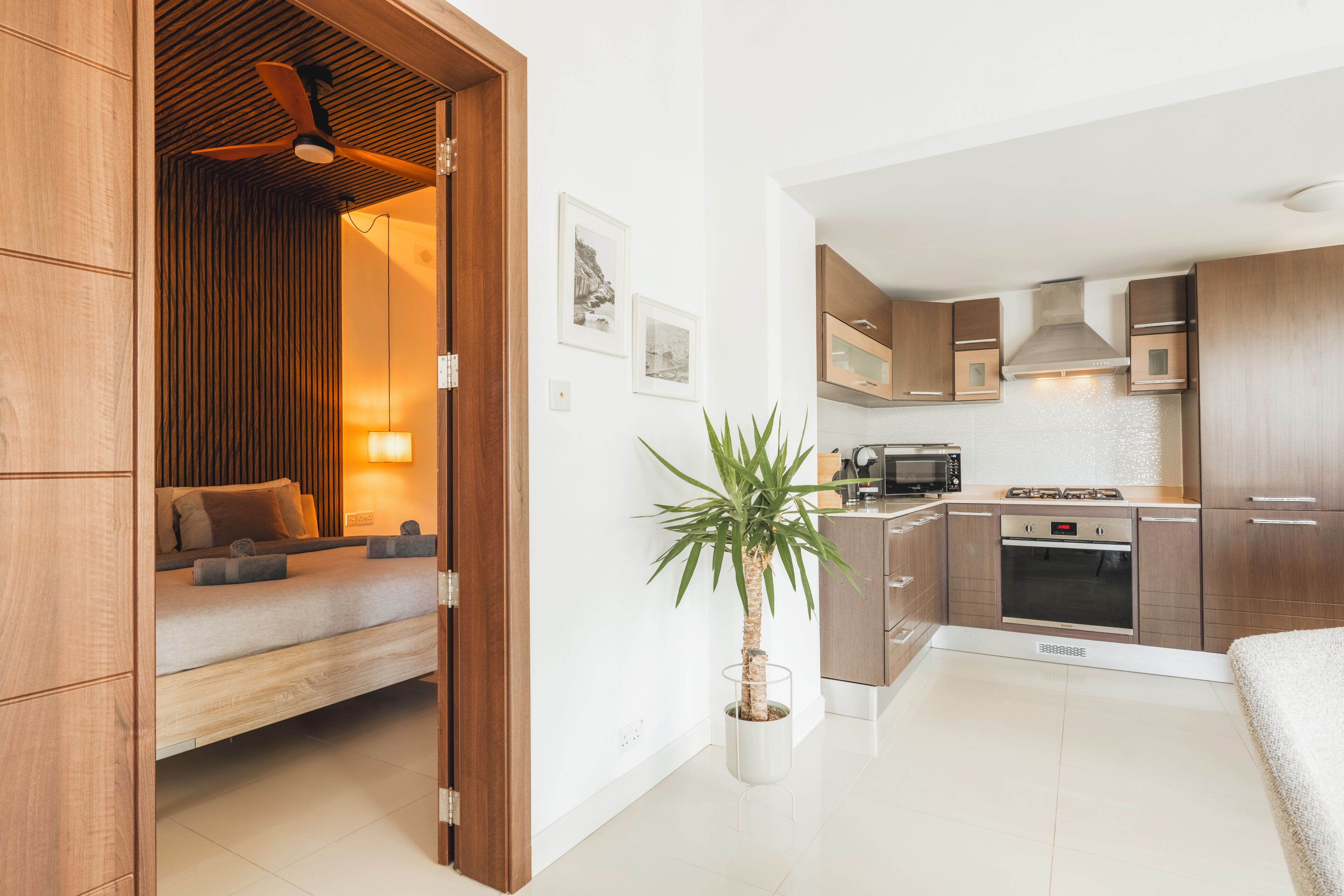A modern kitchen with wooden cabinets, a microwave, stove, and a dining area with a table and chairs.