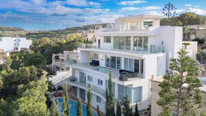 A multi-story modern building with a pool, surrounded by trees. - Villa Marni (Munxar)