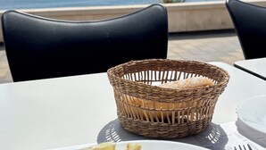 A table with a plate of food, a wicker basket, and a view of the sea. - Oasis of well-being, breathtaking sea view, pool, 4 bedrooms (Carraspite)
