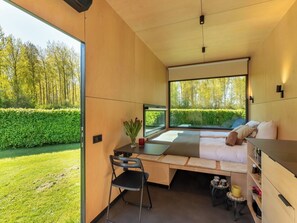 A modern room with a large window, a bed, a desk, and a chair. - Lovely apartment for 2 guests with WIFI and pets allowed (Kerkwerve)