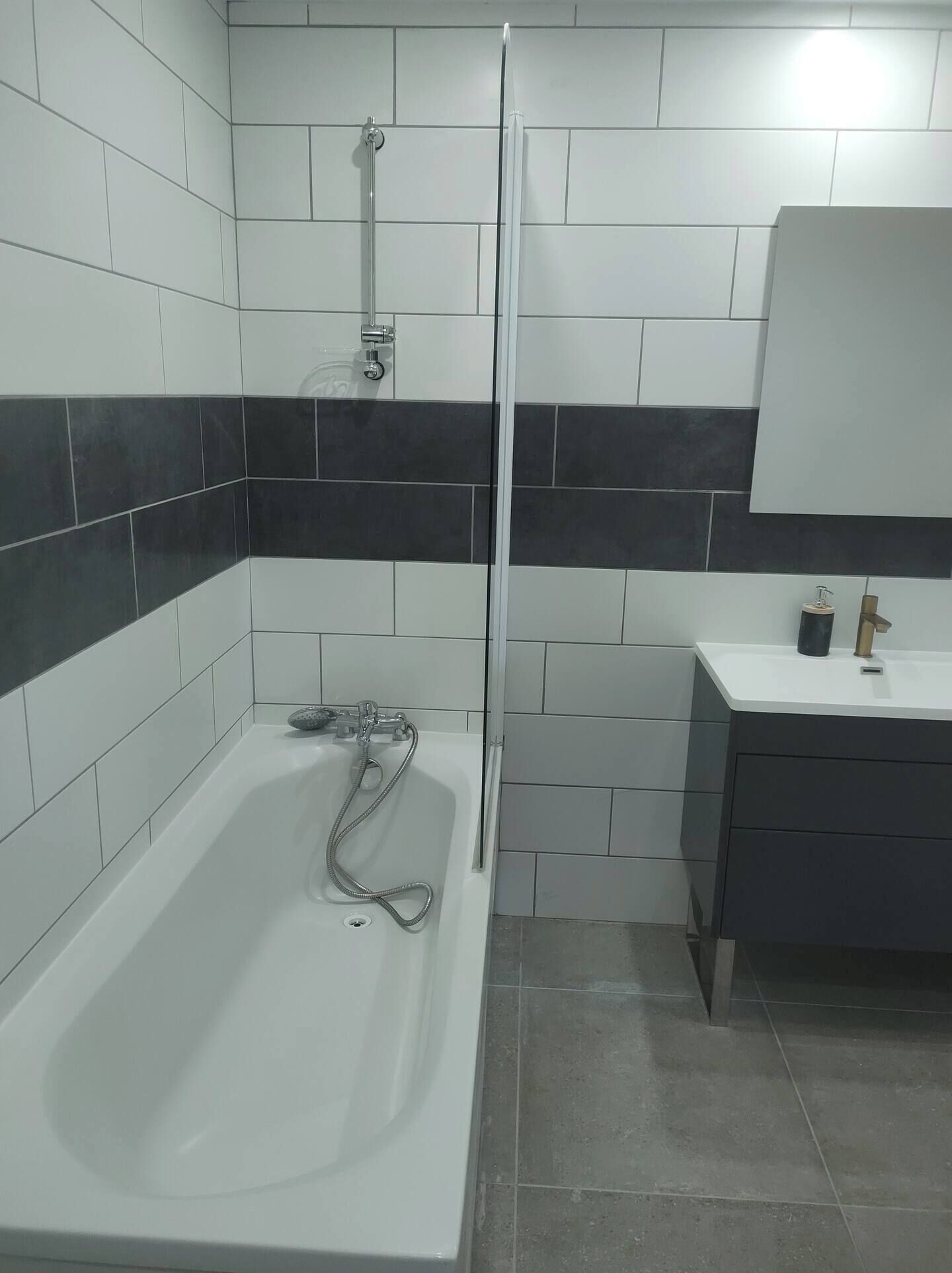 Un baño con bañera, ducha, lavabo y espejo.