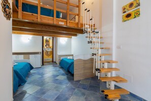 A room with a bunk bed, a wooden staircase, and a bed with a blue bedspread. - Edo's Loft, Studio Apartment with Mezzanine (Alghero)