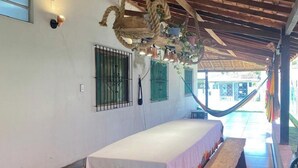 A room with a hammock, a bed with a white bedspread, and a wooden ceiling. - Casa de Praia Na Ilha de Marajó - Joanes/PA (Salvaterra)