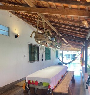 A room with a hammock, a bed with a white bedspread, and a wooden ceiling. - Casa de Praia Na Ilha de Marajó - Joanes/PA (Salvaterra)