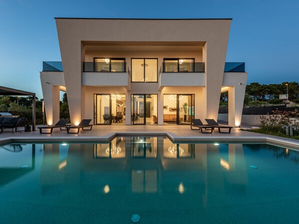 A modern two-story house with a swimming pool in the foreground. - Villa Odeona ZadarVillas (Zadar)