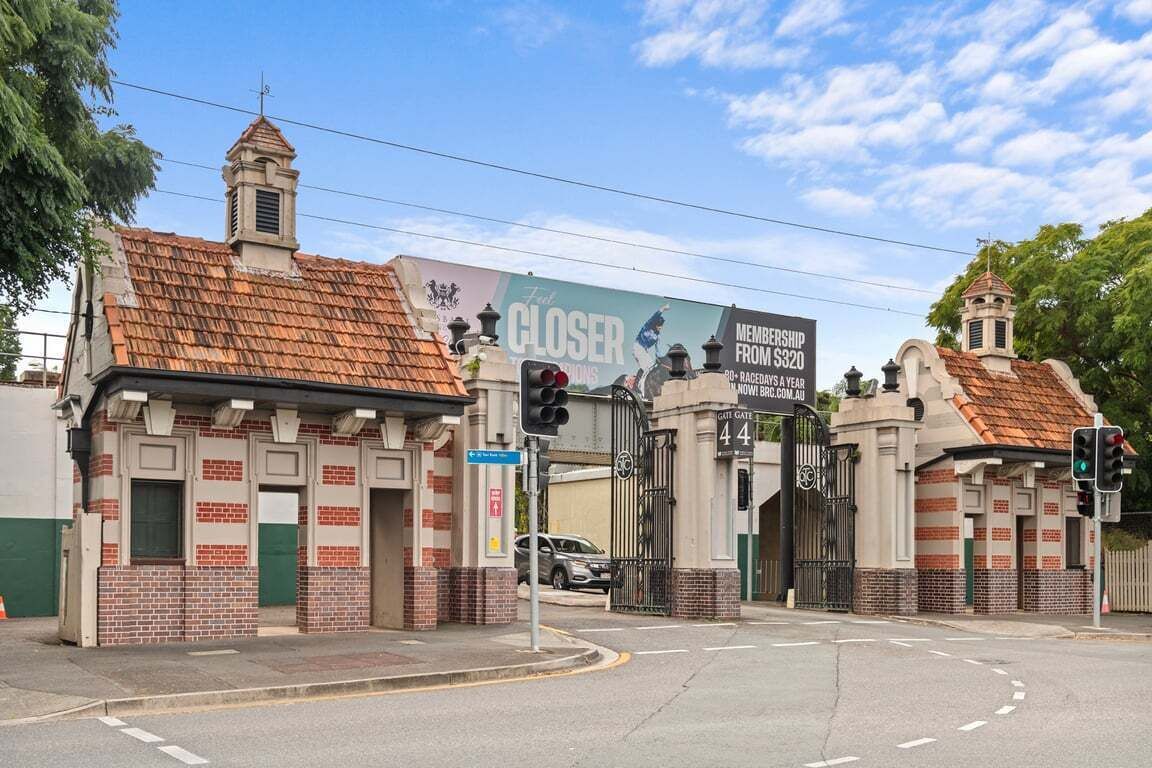 En lukket indgang med et skilt, der angiver medlemskab fra 320 dollars, en murbygning med et tag af fliser og et lyssignal.