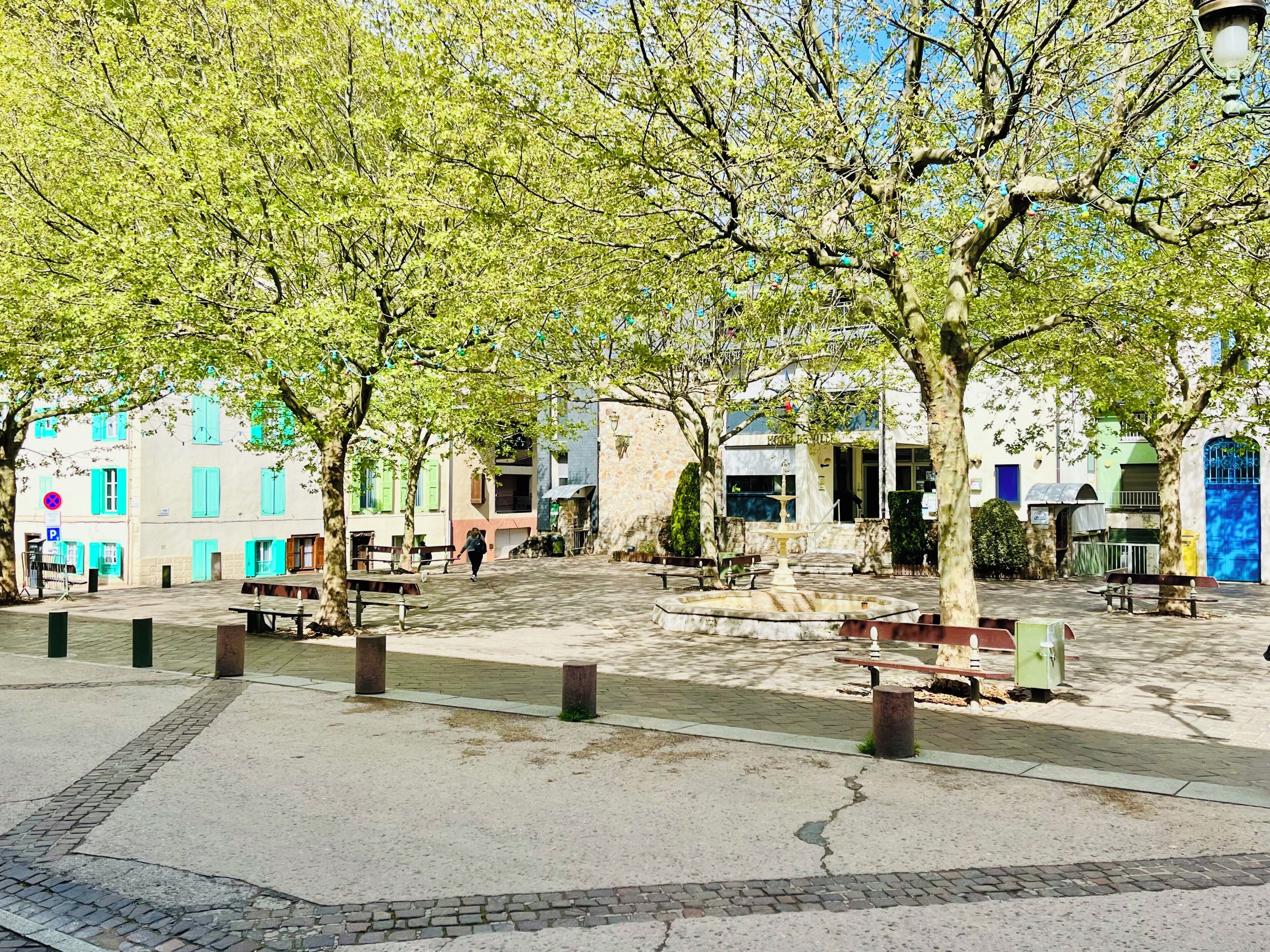 Un patio con árboles, bancos y edificios de diversos estilos arquitectónicos.