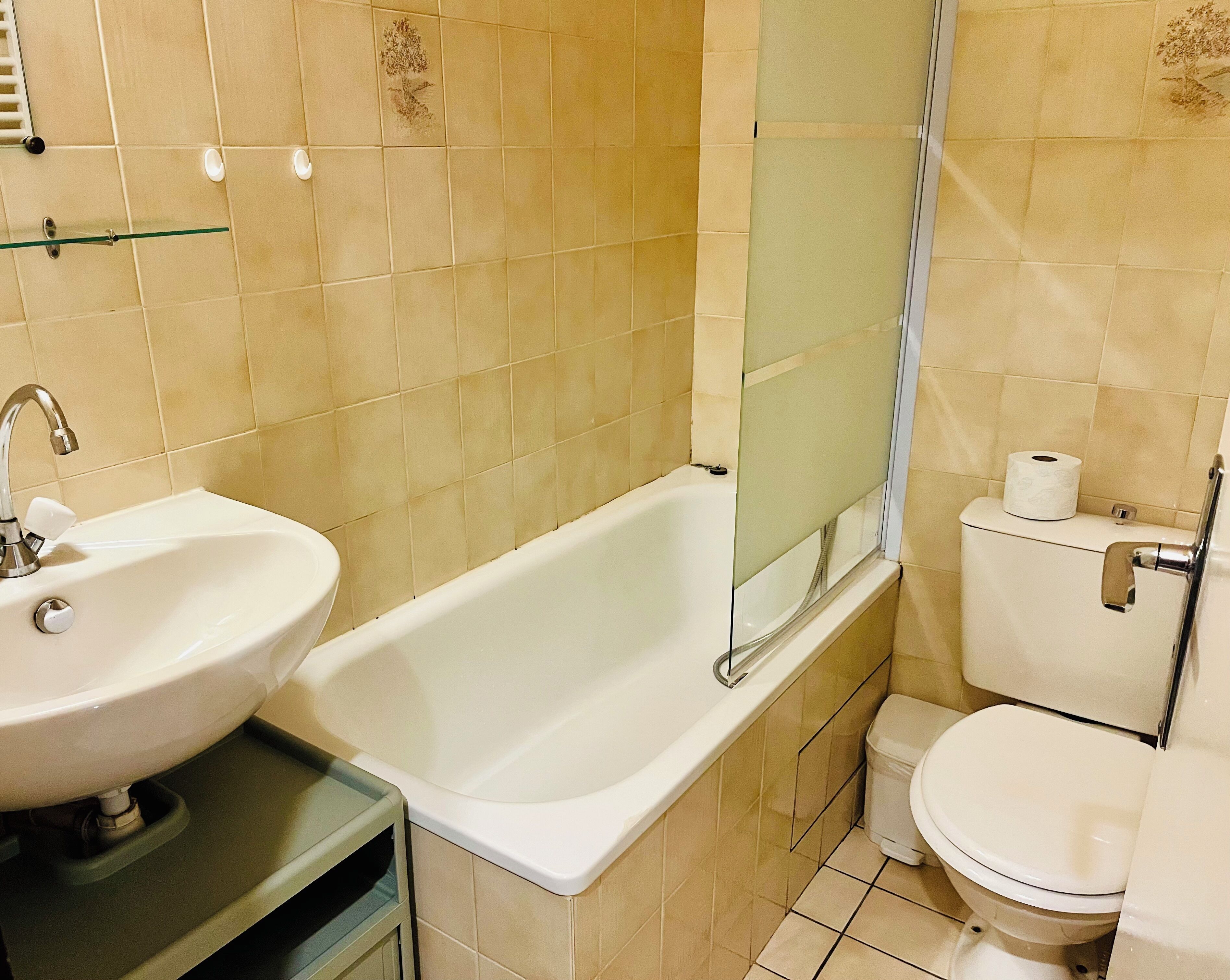 Ein Badezimmer mit Waschbecken, Badewanne, Toilette und einer Duschkabine aus Glas.