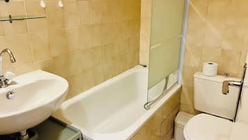 Ein Badezimmer mit Waschbecken, Badewanne, Toilette und einer Duschkabine aus Glas.
