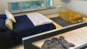 A room with two beds, a window with a view, a mounted TV, and a wooden ceiling. - The Stable, Sleeps 2 With Parking (Llanfairpwllgwyngyll)
