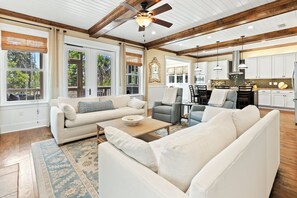 A spacious living area with a large sofa, a coffee table, and a ceiling fan. - NatureWalk "Sandy Paws" 3BR + Bunk | Sleeps 10 | Golf Cart | Pets OK | 🐶 (Santa Rosa Beach)