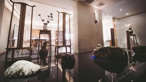 Een modern interieur met glazen scheidingswanden, houten meubels en een spiegelende vloer.